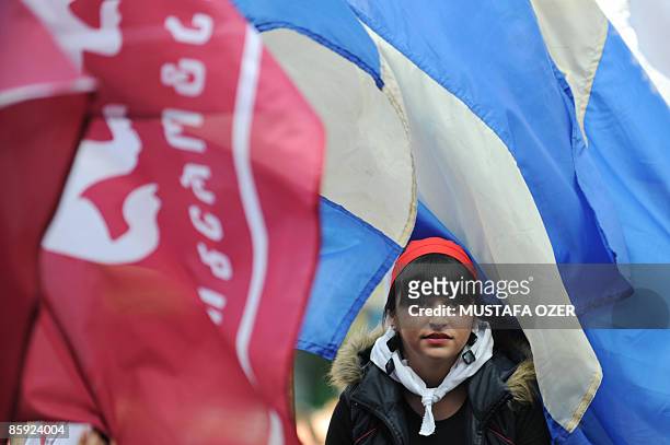 Young Georgian activist is seen between oppositon party flags during an anti-Saakashvili rally in front of the parliament building in Tbilisi on...