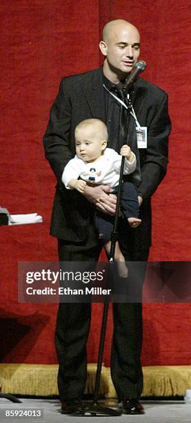 Andre Agassi's 11-month-old son Jaden Agassi grabs the microphone stand as his father speaks at an auction during Andre Agassi's Grand Slam for...