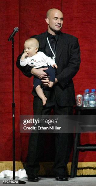 Andre Agassi holds his 11-month-old son Jaden Agassi as the tennis star speaks at an auction during Andre Agassi's Grand Slam for Children benefit...