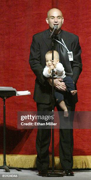 Andre Agassi's 11-month-old son Jaden Agassi grabs the microphone stand as his father speaks at an auction during Andre Agassi's Grand Slam for...