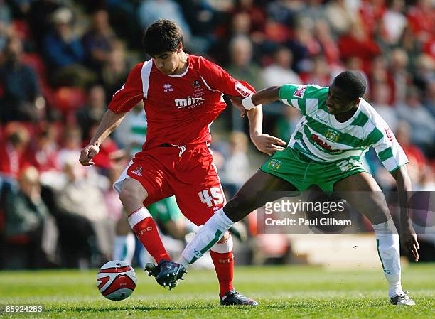 Jonathan Obika of Yeovil Town battles for the ball with Yuri Berchiche of Cheltenham Town during the Coca-Cola League One match between Cheltenham...