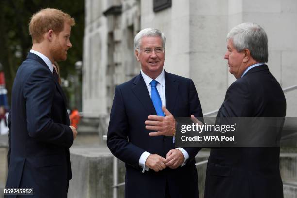 Britain's Prince Harry is greeted by Defence Secretary, Michael Fallon and the Chair of the Royal Foundation, Keith Mills, as he arrives to speak at...