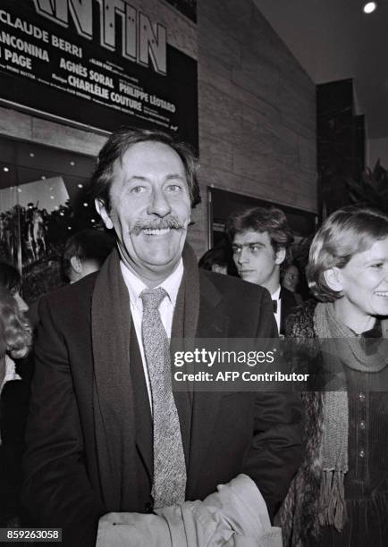 Acteur français Jean Rochefort sort du cinéma Gaumont des Champs-Elysées, accompagné de l'actrice Nicole Garcia, le 05 décembre 1983 à Paris, après...