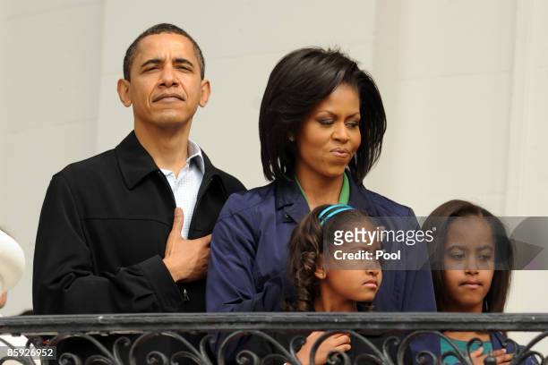 President Barack Obama and first lady Michelle Obama observe the U.S. National Anthem with their two daughters Sasha Obama and Malia Obama before the...