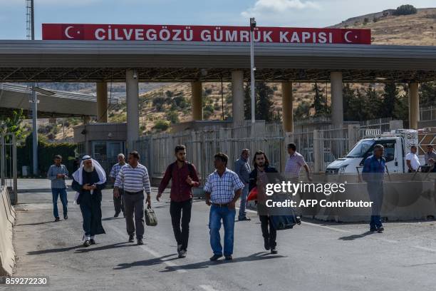 Syrian people carry their belongings as they cross the cilvegozu border gate to Turkish side on october 9, 2017 at Reyhanli district in Hatay. The...