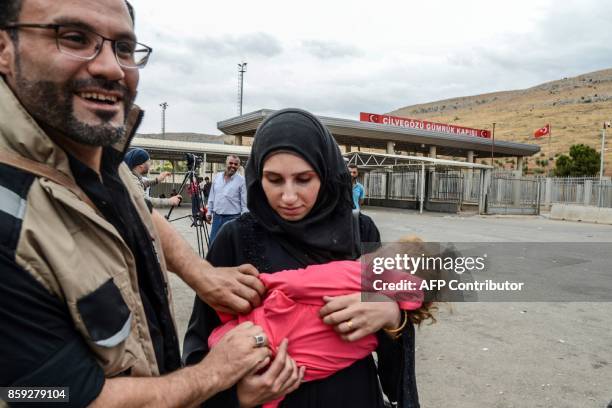 Syrian couple and their daugther cross the cilvegozu border gate to Turkish side on october 9, 2017 at Reyhanli district in Hatay. The Turkish army...