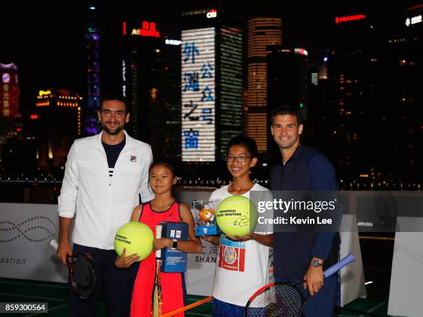 Marin Cilic and Grigor Dimitrov pose for a picture with the some children after their mini-tournament at Fosun Foundation at the Bund on Day 2 of...
