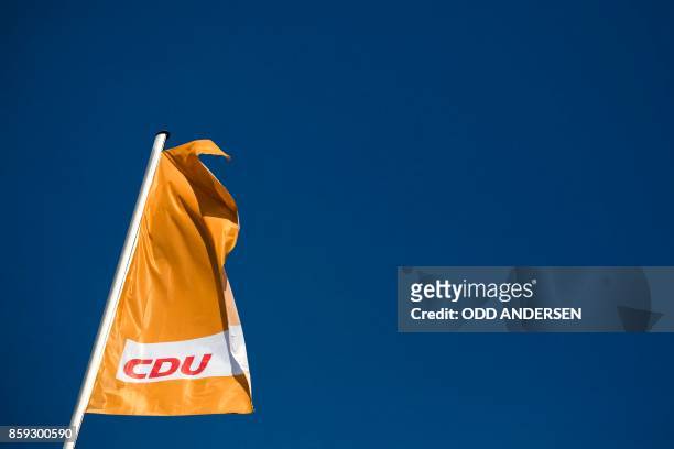Picture taken on October 9, 2017 shows a flag with the logo of the German Christian Democratic Union party fluttering above the party´s headquarters...