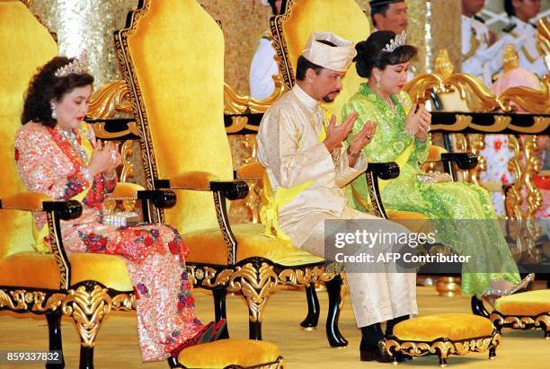 Bruneian Sultan Hassanal Bolkiah and his wives Queen Saleha and Queen Mariam pray to mark the Sultan's 53rd birthday 15 July 1999 at the Istana Nurul...