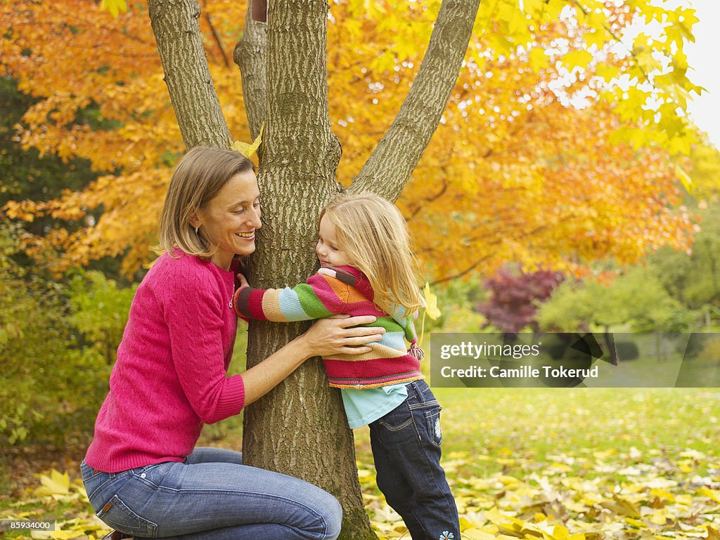 Mother with daughter hugging a tree, Autumn