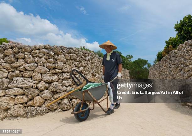 Gardener in a sandy alley in hoshinoya hotel, Yaeyama Islands, Taketomi island, Japan on September 1, 2017 in Taketomi Island, Japan.