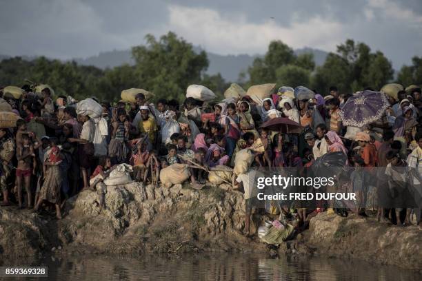 Rohingya refugees wait after crossing the Naf river from Myanmar into Bangladesh in Whaikhyang on October 9, 2017. A top UN official said on October...