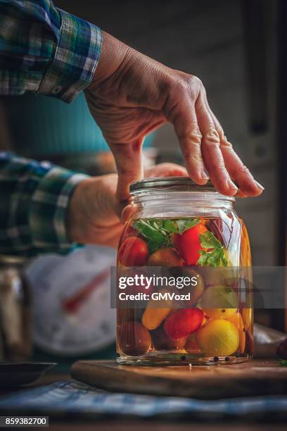 behoud van de biologische gemengd gekleurde cherry tomaten in potten - pickle jar stockfoto's en -beelden