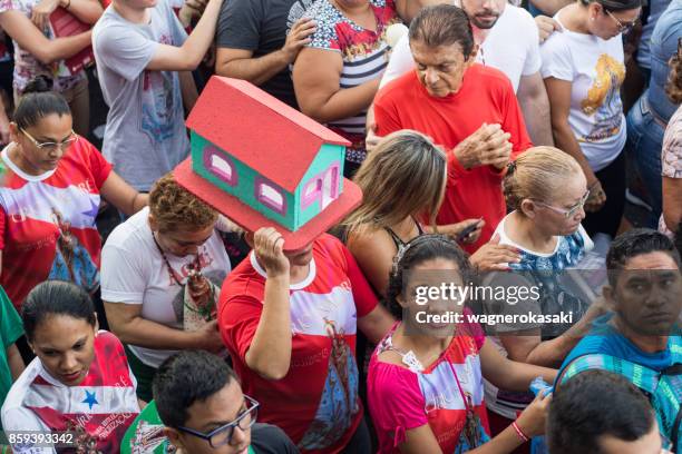 pilgrim carrying a miniature of a house thanking and paying a promise - petite parade stock pictures, royalty-free photos & images