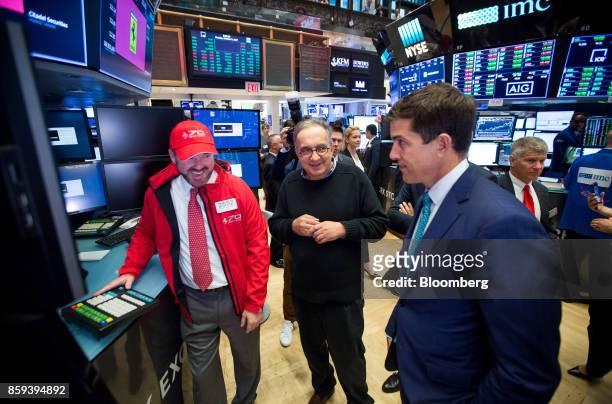 Sergio Marchionne, chief executive officer of Ferrari NV, center, and Tom Farley, president of NYSE Group Inc., right, speak with a trader on the...