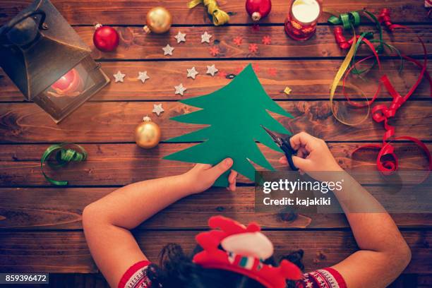 kleine mädchen machen weihnachtskarte - candle overhead stock-fotos und bilder