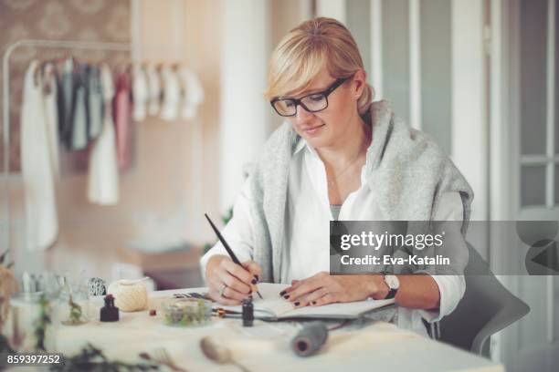 junge geschäftsfrau schreibt in ein persönlicher organizer - kalligraphieren stock-fotos und bilder