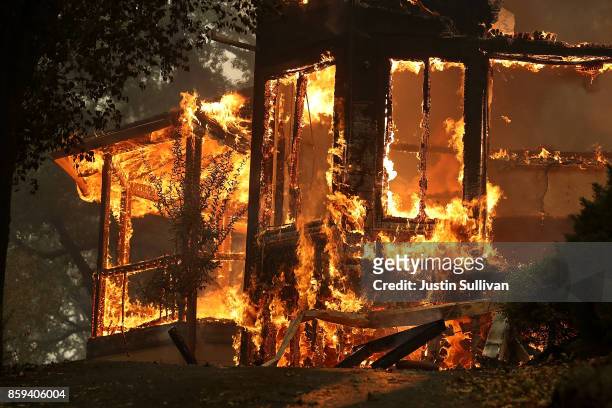 Flames consume a home as an out of control wildfire move through the area on October 9, 2017 in Glen Ellen, California. Tens of thousands of acres...