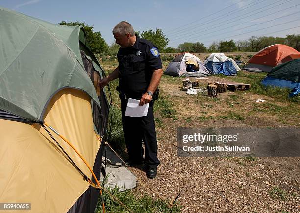 Sacramento police officer Mark Zoulas delivers eviction notices to residents at a homeless tent city April 13, 2009 in Sacramento, California....