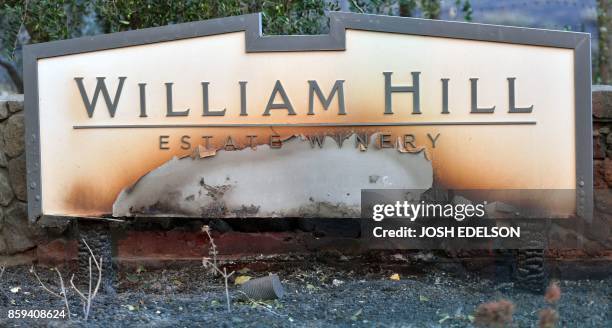 The William Hill Estate Winery sign is seen partially burnt in Napa, California on October 9 as multiple wind-driven fires continue to whip through...