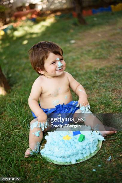 barnet leker med en tårta under cake smash födelsedagsfest - smash cake bildbanksfoton och bilder