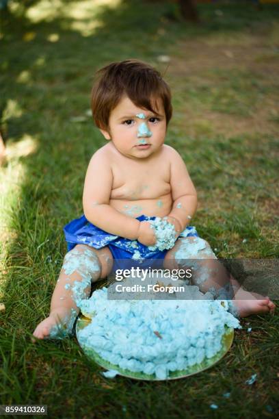 baby spelen met een taart tijdens cake smash verjaardagsfeestje - smash cake stockfoto's en -beelden