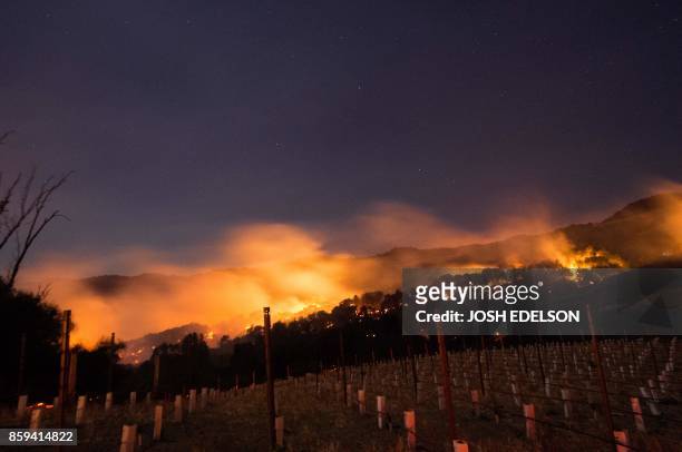 Fire glows on a hillside in Napa, California on October 9 as multiple wind-driven fires continue to whip through the region.