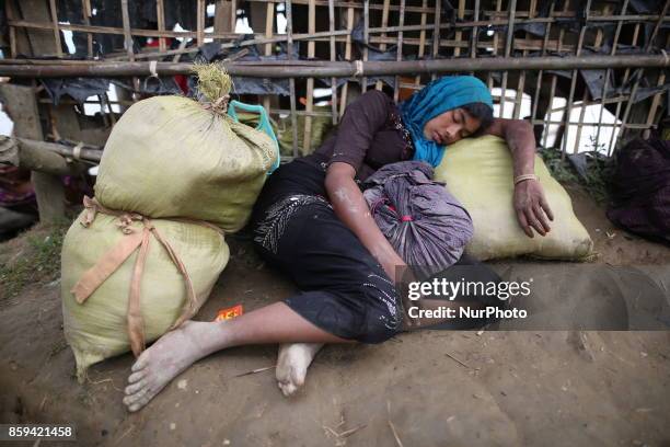 Rohingya Muslims, fled from ongoing military operations in Myanmars Rakhine state make their way through muddy water after crossing the...