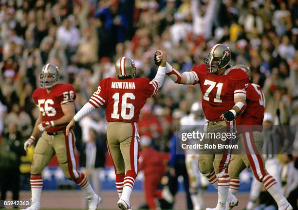 San Francisco 49ers tackle Keith Fahnhorst high-fives Hall of Fame quarterback Joe Montana after a 31-yard touchdown pass during Super Bowl XIX, a...