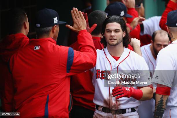 Andrew Benintendi of the Boston Red Sox celebrates with teammates in the dugout after hitting a two-run home run in the fifth inning against the...