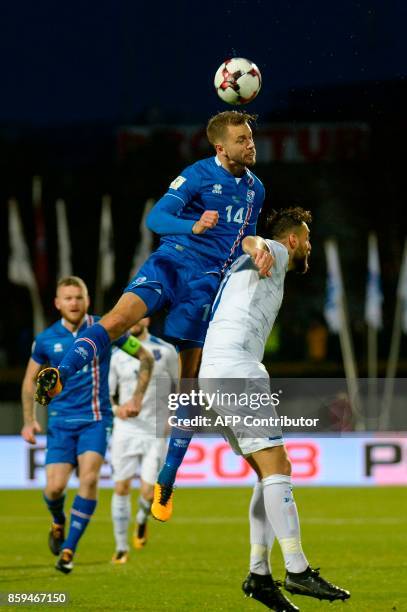 Iceland's defender Kari Arnason wins an aerial battle to head the ball during the FIFA World Cup 2018 qualification football match between Iceland...