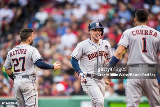 Alex Bregman of the Houston Astros reacts with Jose Altuve and Carlos Correa after hitting a game tying solo home run during the eighth inning of...