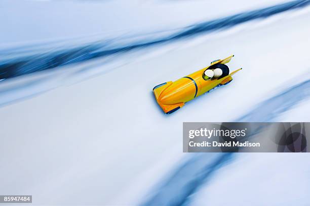 bobsled on track with motion blur. - bobsleigh team stock-fotos und bilder