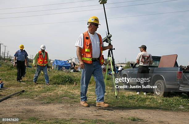 Sacramento Municipal Utilities District workers prepare to mark property lines in order to erect a fence at a homeless tent city April 13, 2009 in...