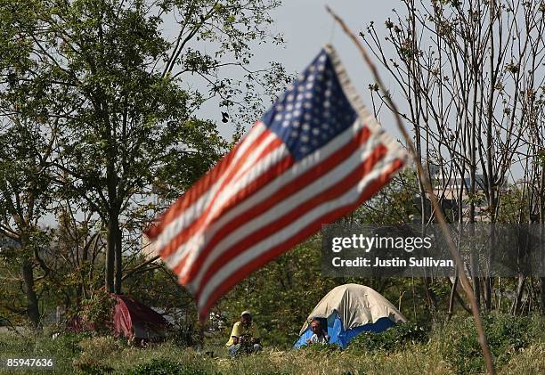 An American flag flies over a homeless tent city April 13, 2009 in Sacramento, California. Hundreds of residents living in a tent city along the...