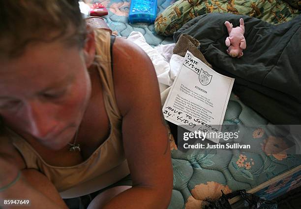 Renee Hadley, a homeless woman, sits in her tent after being issued a notice of eviction by the Sacramento police at a homeless tent city April 13,...