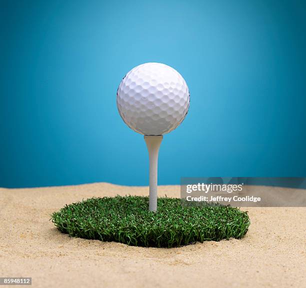 golf ball on tee surrounded by sand trap - sand trap imagens e fotografias de stock