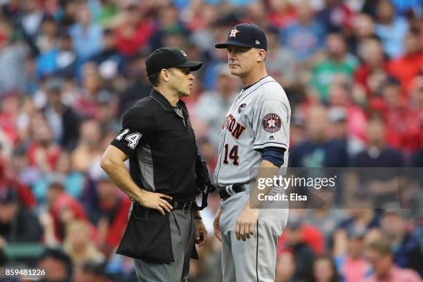 Manager A.J. Hinch of the Houston Astros talks with umpire Mark Wegner during game four of the American League Division Series at Fenway Park on...