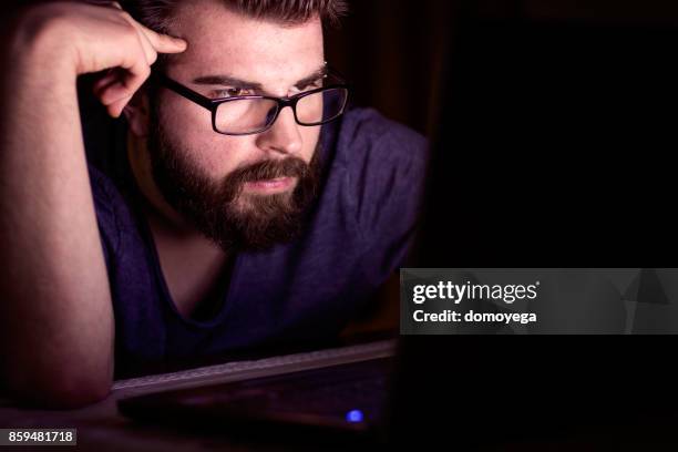 handsome man working late on laptop - web browser stock pictures, royalty-free photos & images