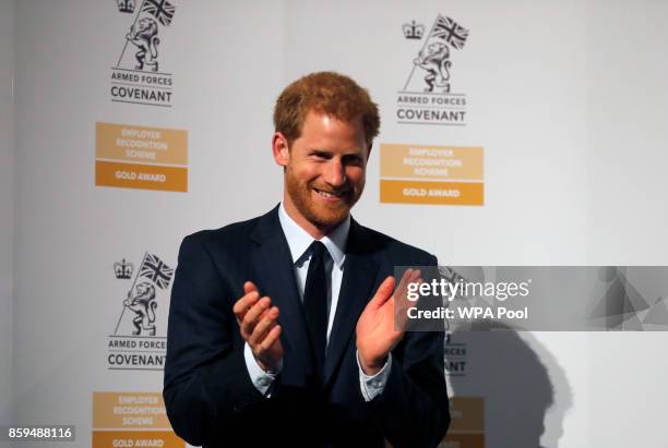 Britain's Prince Harry applauds as he presents the Employer Recognition Scheme Gold Awards at the Imperial War Museum on October 9, 2017 in London,...