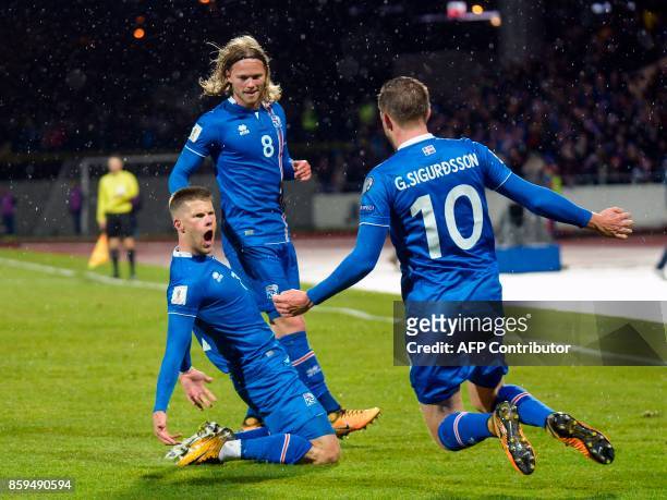 Iceland's forward Johann Berg Gudmundsson celebrates scoring with his team-mates Iceland's midfielder Birkir Bjarnason and Iceland's midfielder Gylfi...