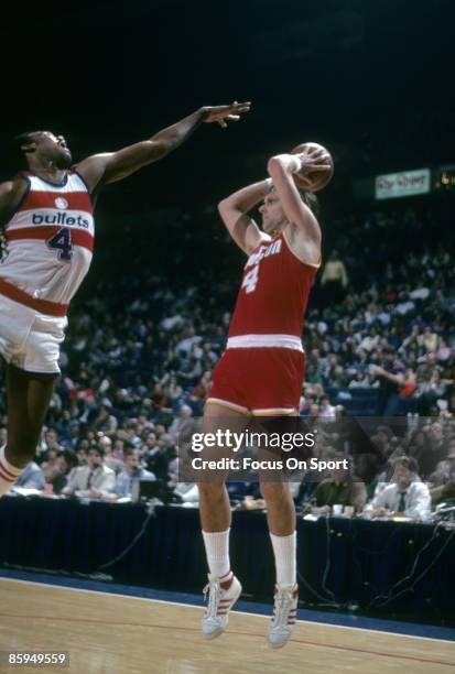 Rick Barry of the Houston Rockets looks to pass the ball over the out stretched arm of a Washington Bullets defender during a circa 1978 NBA...