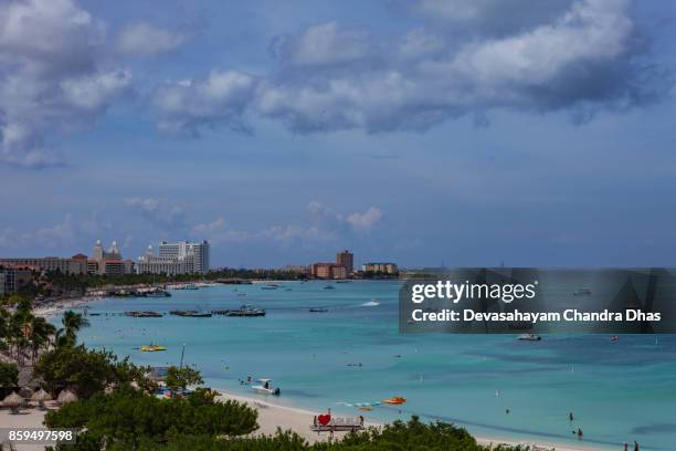 toeristische resort van palm beach in aruba op de zuid-caribische zee in de ochtendzon. verschillende luxe beach hotels en boten op anker offshore. - palm beach aruba stockfoto's en -beelden