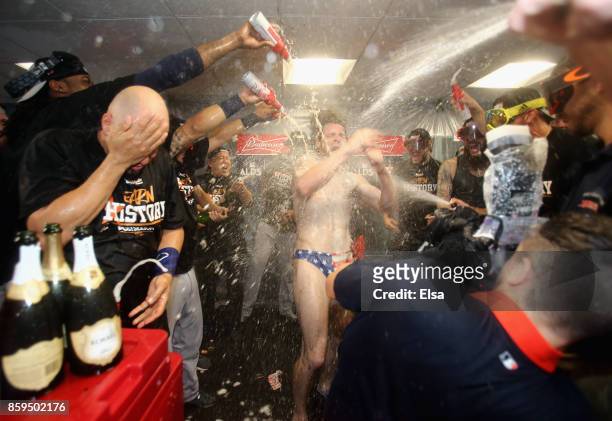 Josh Reddick of the Houston Astros celebrates with teammates in the clubhouse after defeating the Boston Red Sox 5-4 in game four of the American...