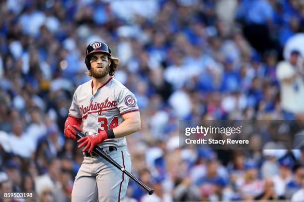 Bryce Harper of the Washington Nationals walks back to the dugout after striking out in the sixth inning against the Chicago Cubs during game three...