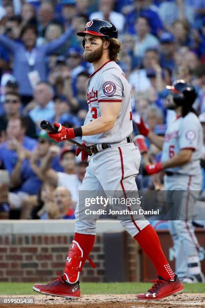 Bryce Harper of the Washington Nationals walks back to the dugout after striking out in the sixth inning against the Chicago Cubs during game three...