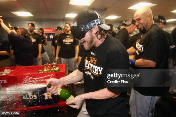 Josh Reddick of the Houston Astros celebrates with teammates in the clubhouse after defeating the Boston Red Sox 5-4 in game four of the American...