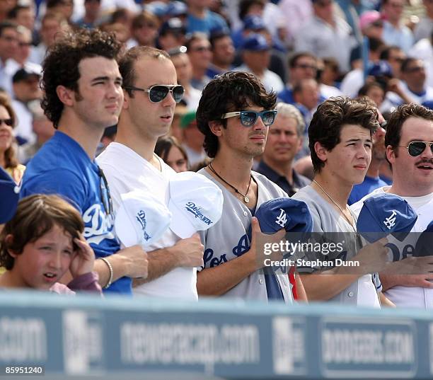 Kevin Jonas , Joe Jonas second from R) and Nick Jonas of the Jonas Brothers stand during the singing of God Bless Americas during the seventh inning...