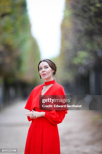 Ulyana Sergeenko is seen wearing a red dress, at the Tuileries garden on October 7, 2017 in Paris, France.