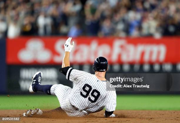 Aaron Judge of the New York Yankees slides safely into second base after hitting a two-run double in the second inning during Game 4 of the American...